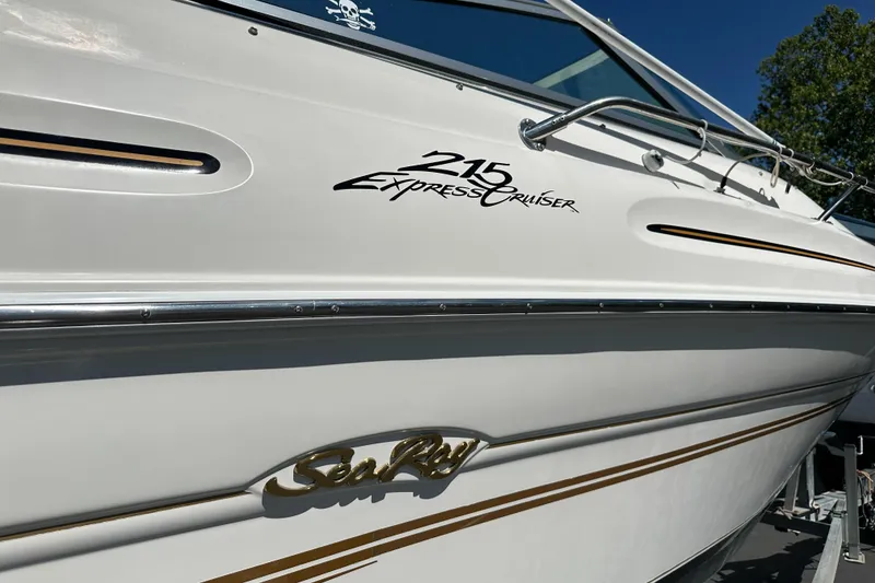 Slide: The Image of 1998 Sea Ray 215 Express Cruiser boat with sleek white exterior and elegant branding. - 30