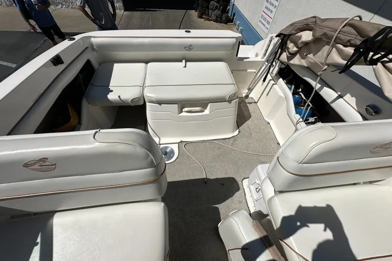 Slide: The Image of 1998 Sea Ray 215 Express Cruiser interior with white seating and storage compartments. - 9