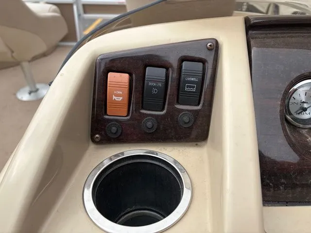 Slide: The Image of Dashboard of a 2012 Bennington 20 SF with switches and cup holder. - 16