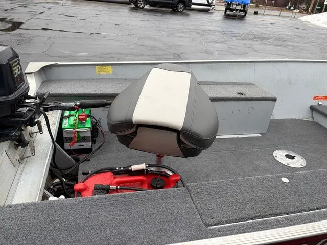 Slide: The Image of Interior of a 1997 Lund 14 Rebel boat with seat and motor. - 13
