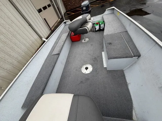 Slide: The Image of Interior view of a 1997 Lund 14 Rebel boat with gray carpet flooring. - 14