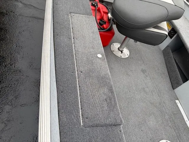 Slide: The Image of Interior of a 1997 Lund 14 Rebel boat with gray carpet flooring. - 18