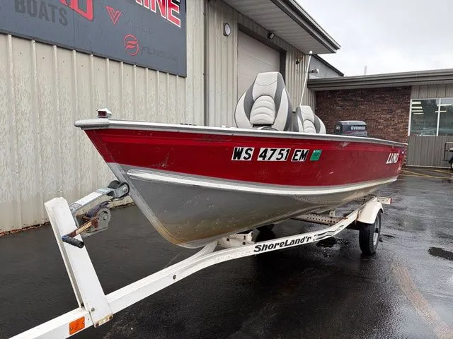 Slide: The Image of Red 1997 Lund 14 Rebel boat on trailer outside warehouse. - 3