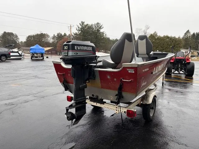 Slide: The Image of Red 1997 Lund 14 Rebel boat with Evinrude motor on trailer. - 7