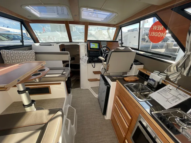 Slide: The Image of 2023 Cutwater C-288 interior with helm, seating, and kitchenette. - 25