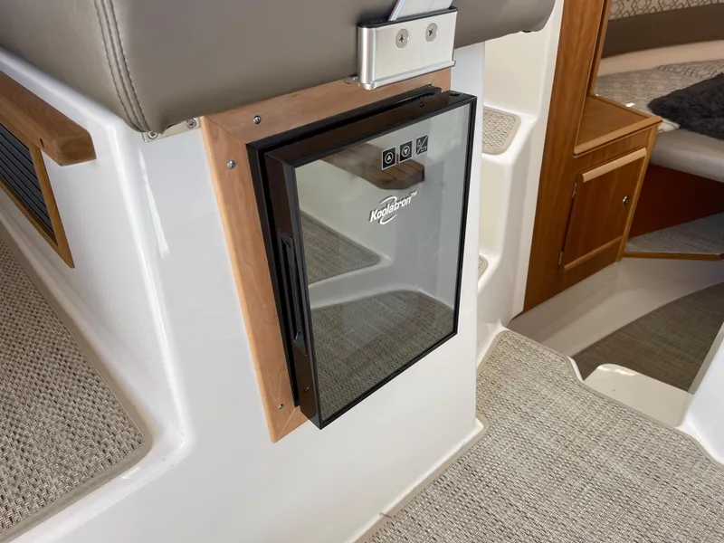 Slide: The Image of Cutwater C-288 2023 model interior, featuring a built-in mini fridge and carpeted flooring. - 39