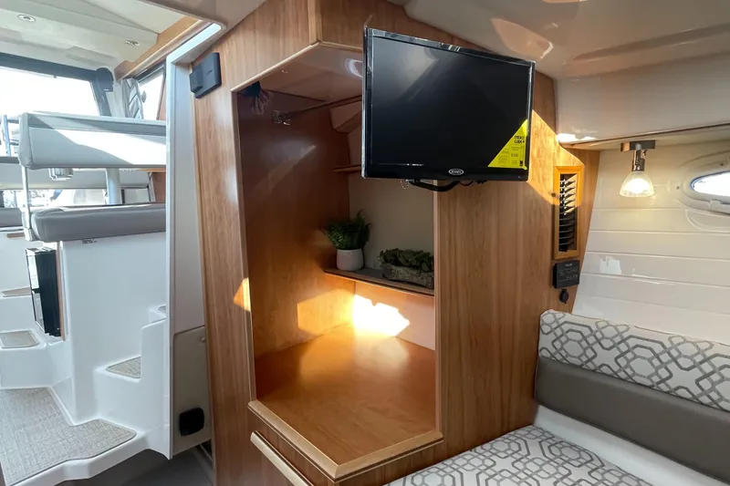 Slide: The Image of 2023 Cutwater C-288 interior with TV, wooden cabinetry, and seating area. - 41