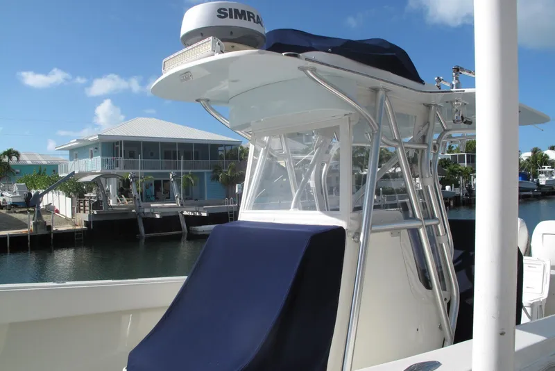 Slide: The Image of 2017 SeaVee 340B boat docked near waterfront homes under a clear blue sky. - 2