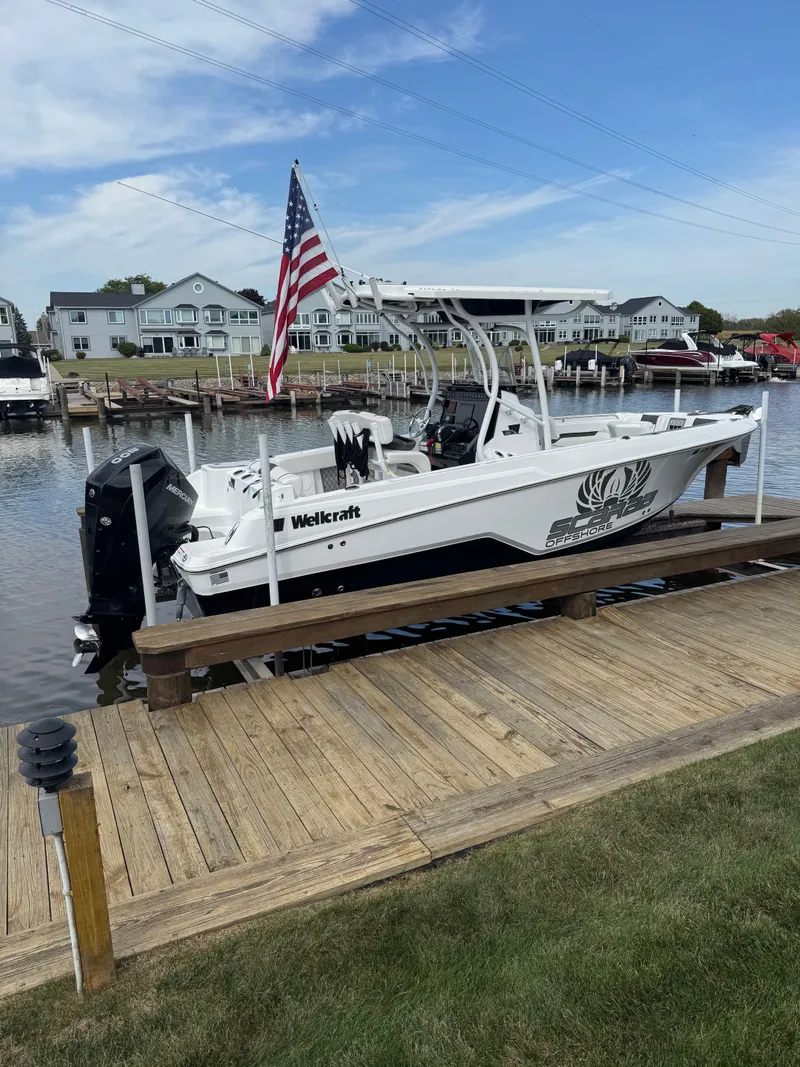 The Image of 2021 Wellcraft 222 Fisherman boat docked with American flag. - 0