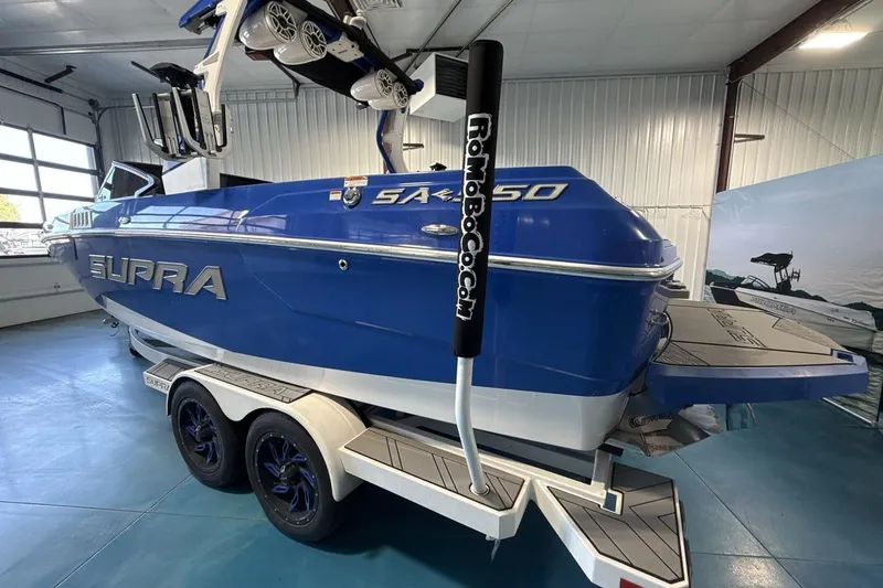 Slide: The Image of 2019 Supra SA 550 boat in a showroom, featuring a sleek blue design and dual-axle trailer. - 4
