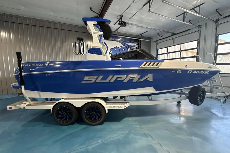Slide: The Image of 2019 Supra SA 550 boat in blue, parked indoors on a trailer. - 7