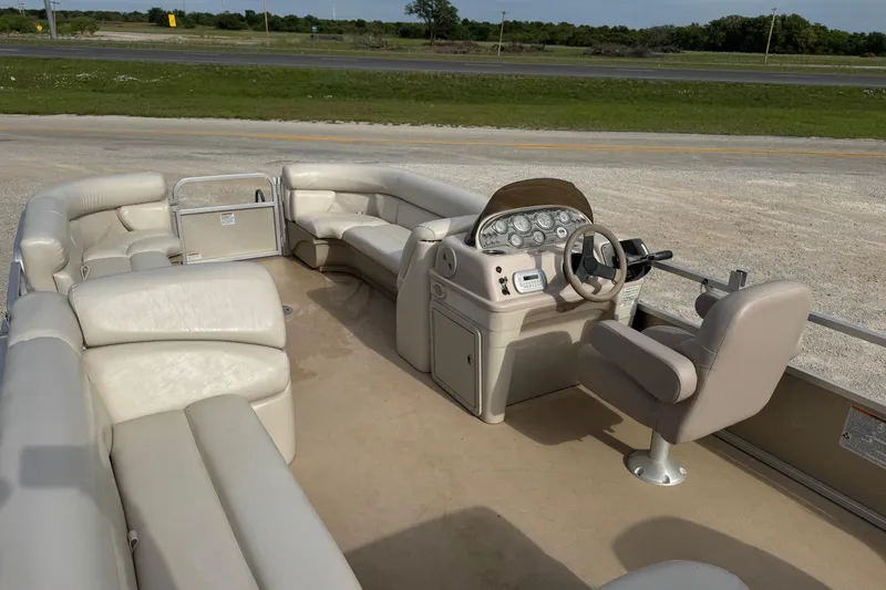 Slide: The Image of 2013 SunChaser 8522 Cruise pontoon boat interior with beige seating and steering console. - 11