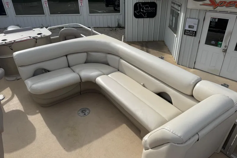 Slide: The Image of 2013 SunChaser 8522 Cruise boat with beige seating, displayed outside a sales and service building. - 5