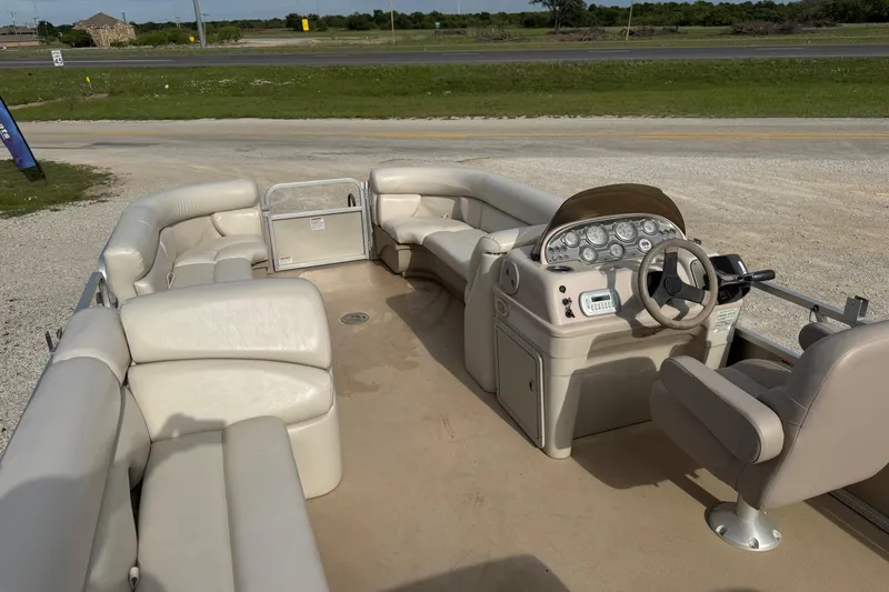 Slide: The Image of 2013 SunChaser 8522 Cruise pontoon boat interior with beige seating and steering console. - 7