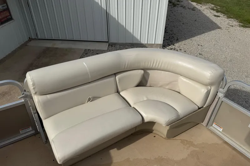 Slide: The Image of Cream leather seating on a 2013 SunChaser 8522 Cruise boat, near a metal building. - 8