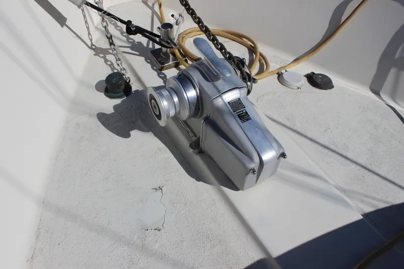 Slide: The Image of Anchor windlass on 1972 Fisher 30 boat deck, featuring chain and rope setup. - 10