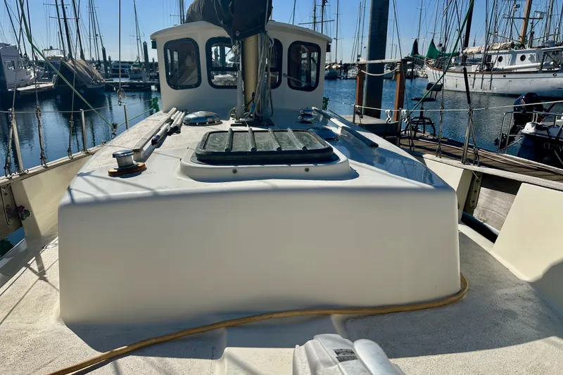 Slide: The Image of 1972 Fisher 30 sailboat docked at marina, showcasing deck and cabin details. - 13
