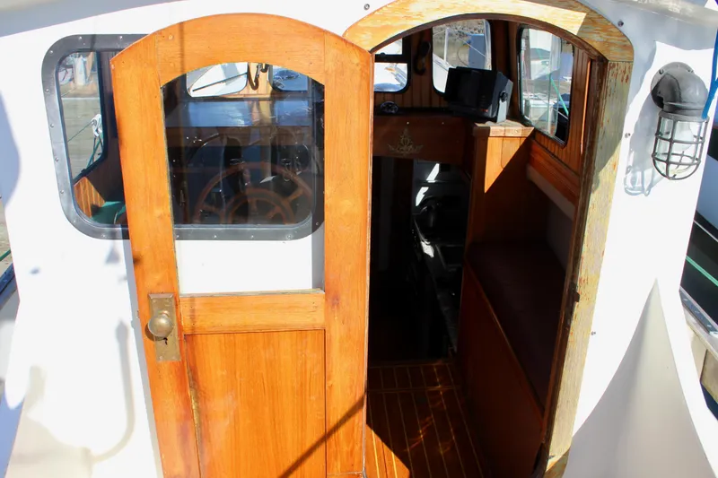 Slide: The Image of 1972 Fisher 30 boat interior with wooden door and steering wheel visible. - 21