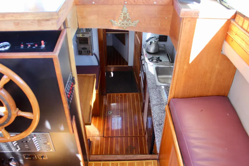 Slide: The Image of Interior of a 1972 Fisher 30 boat with wooden finishes and compact kitchen area. - 35