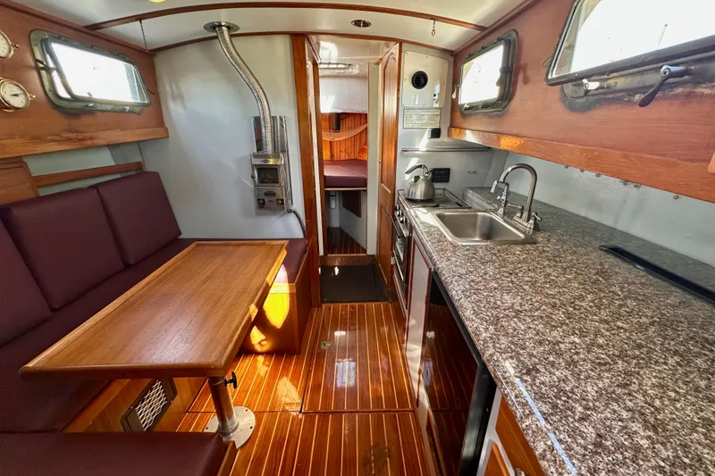 Slide: The Image of Interior of a 1972 Fisher 30 yacht with wooden finishes and a compact kitchen. - 36
