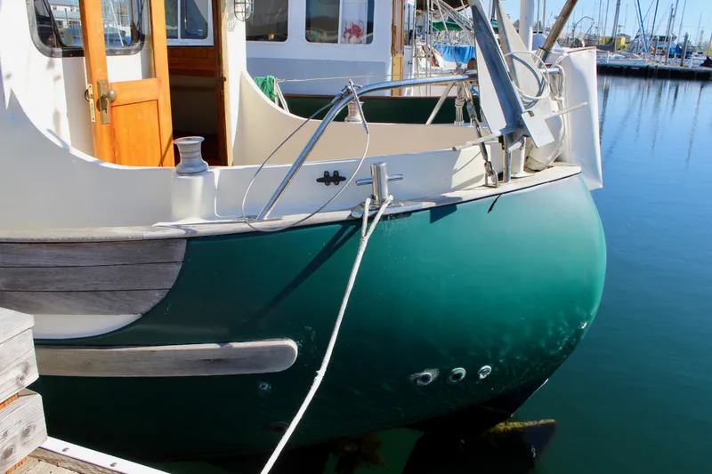 Slide: The Image of 1972 Fisher 30 boat docked, featuring a green hull and wooden accents. - 4