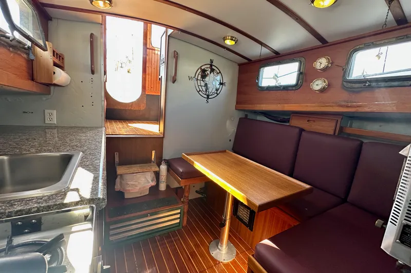 Slide: The Image of Interior of a 1972 Fisher 30 boat with a cozy dining area and kitchenette. - 40
