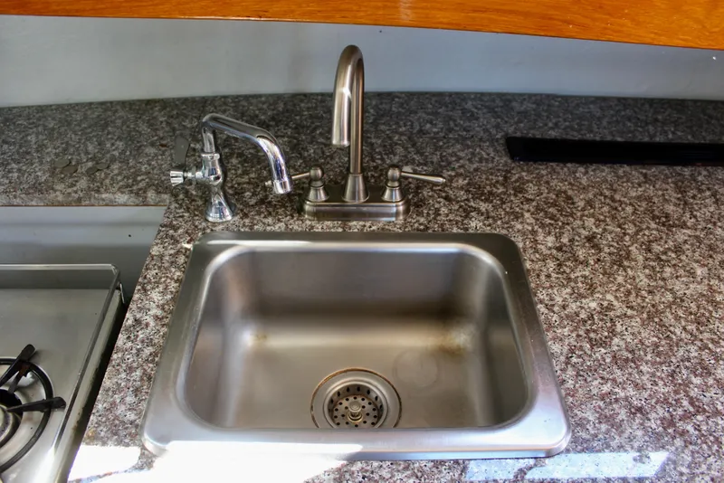 Slide: The Image of Stainless steel sink with faucet on granite countertop in 1972 Fisher 30 boat. - 44