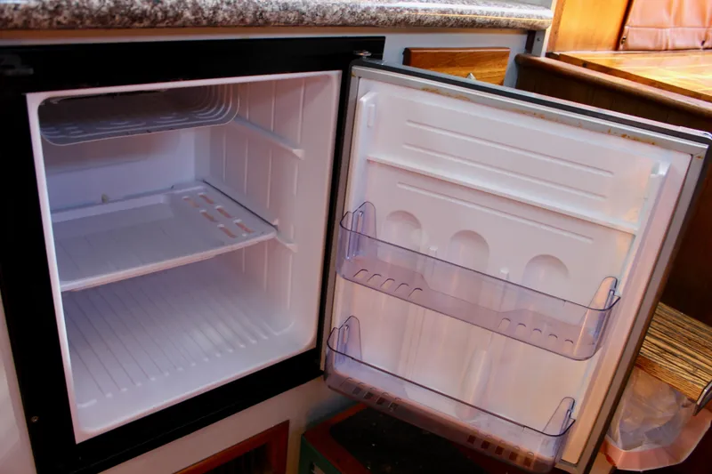 Slide: The Image of Open Fisher 30 refrigerator from 1972, showing empty interior and door shelves. - 45