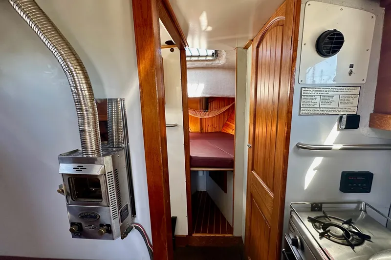 Slide: The Image of Interior of a 1972 Fisher 30 boat with wood paneling and compact stove. - 49