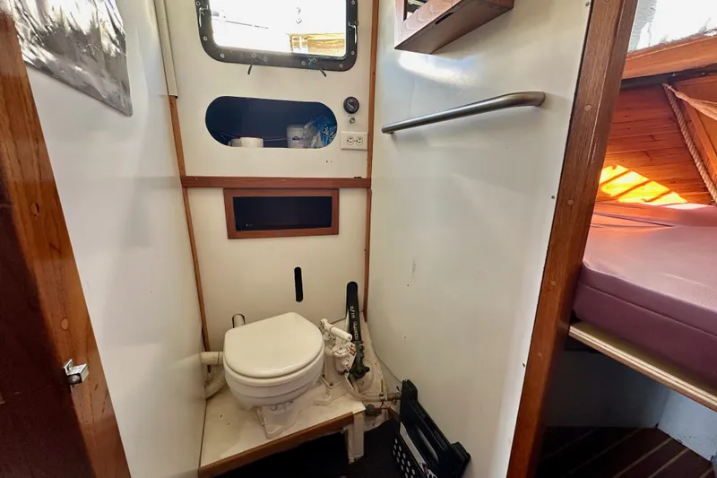 Slide: The Image of 1972 Fisher 30 boat interior with compact bathroom and adjacent sleeping area. - 50