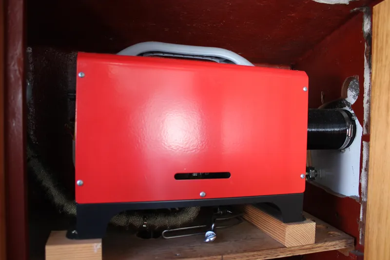 Slide: The Image of Red engine component inside a 1972 Fisher 30 boat, mounted on wooden blocks. - 52