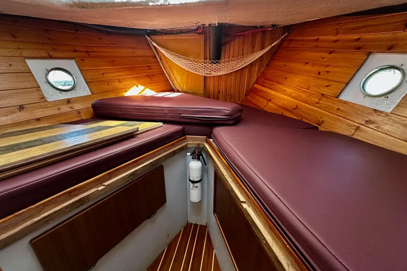 Slide: The Image of Cozy 1972 Fisher 30 boat cabin with wooden interior and maroon cushions. - 53