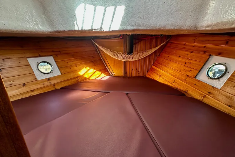 Slide: The Image of Cozy cabin interior of 1972 Fisher 30 boat with wooden paneling and portholes. - 54