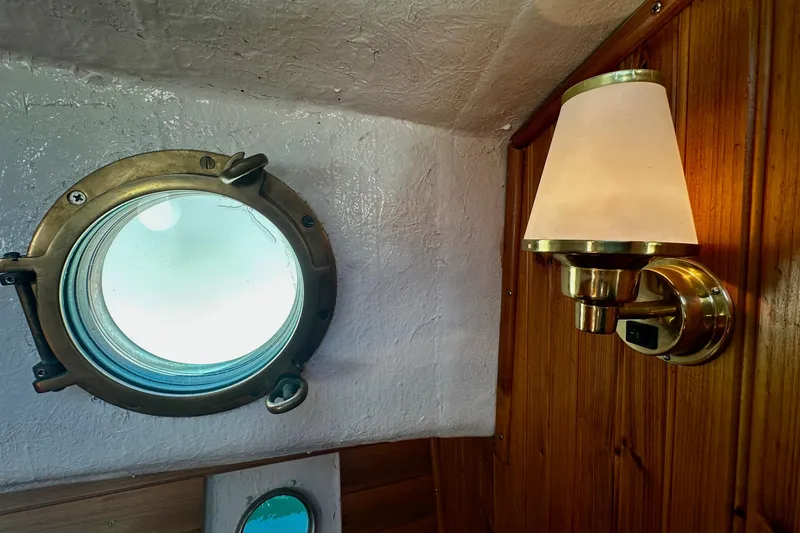 Slide: The Image of Porthole and brass lamp inside a 1972 Fisher 30 boat cabin. - 55