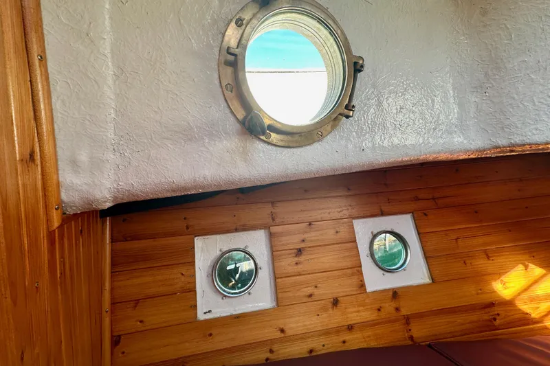 Slide: The Image of Interior of a 1972 Fisher 30 boat with wooden paneling and round portholes. - 56
