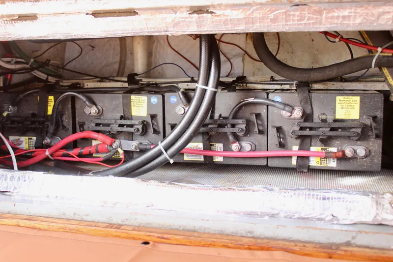 Slide: The Image of Battery compartment of a 1972 Fisher 30 boat, featuring multiple connected batteries. - 57