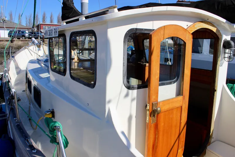 Slide: The Image of 1972 Fisher 30 sailboat with wooden door and windows, docked in a marina. - 6