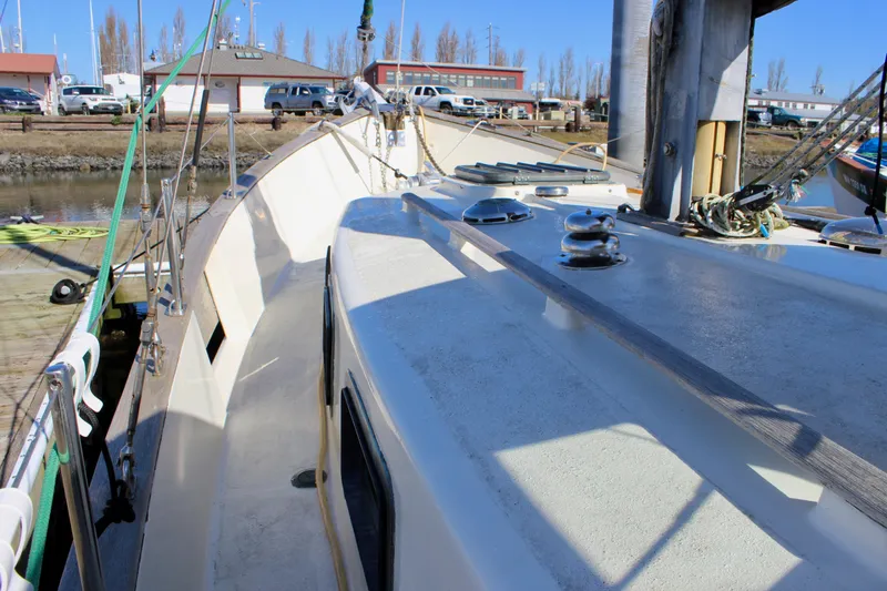 Slide: The Image of 1972 Fisher 30 sailboat deck view at marina, showcasing rigging and fittings. - 8