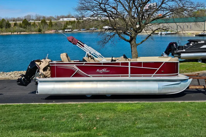The Image of 2023 SunChaser Geneva Fish 22 pontoon boat by a scenic lake. - 0