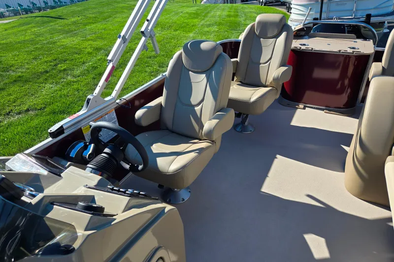 Slide: The Image of 2023 SunChaser Geneva Fish 22 boat interior with beige seating and steering wheel. - 15