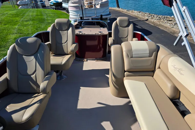 Slide: The Image of 2023 SunChaser Geneva Fish 22 pontoon boat interior with plush seating by the water. - 16