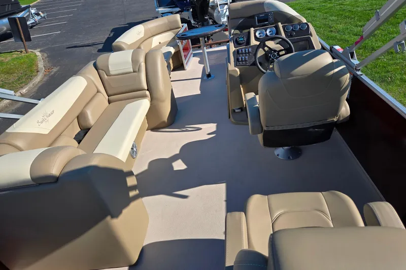 Slide: The Image of 2023 SunChaser Geneva Fish 22 pontoon boat interior with beige seating and modern dashboard. - 21