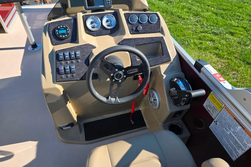Slide: The Image of 2023 SunChaser Geneva Fish 22 boat dashboard with steering wheel and control panel. - 24