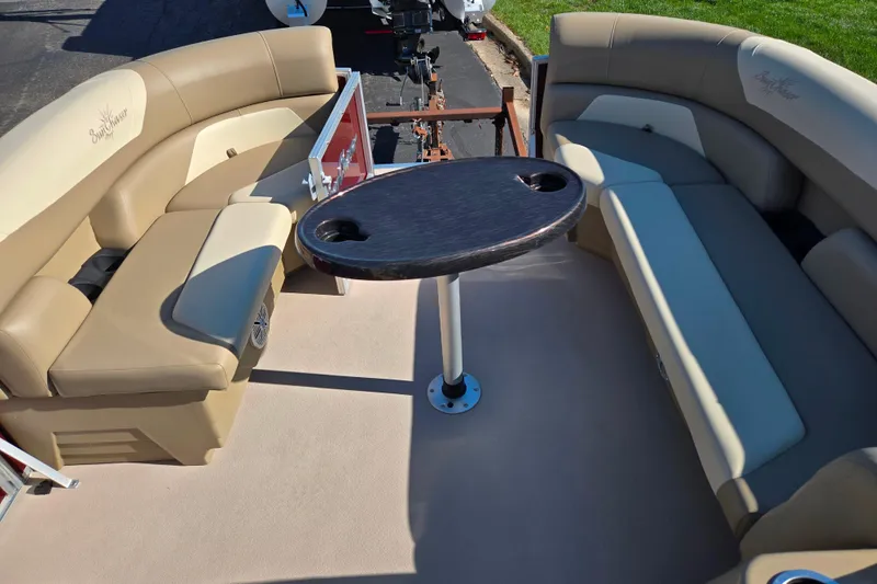 Slide: The Image of 2023 SunChaser Geneva Fish 22 boat interior with beige seating and a central table. - 25