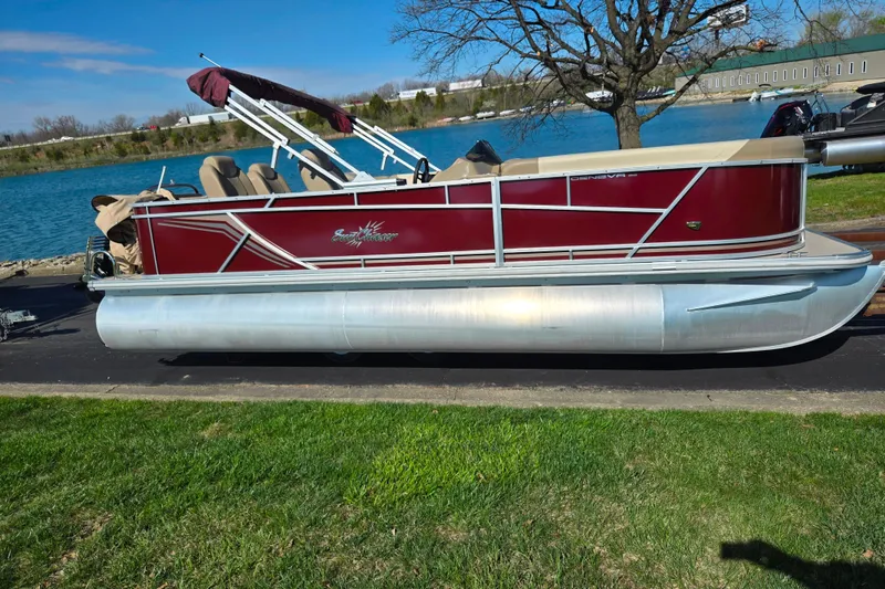 Slide: The Image of 2023 SunChaser Geneva Fish 22 pontoon boat by a lake on a sunny day. - 9