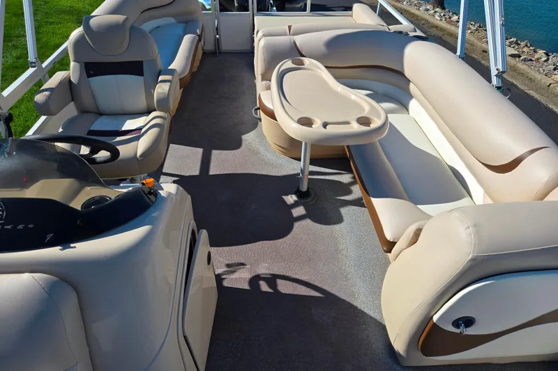 Slide: The Image of 2016 Sun Tracker Party Barge 24 DLX interior with plush seating and table. - 13
