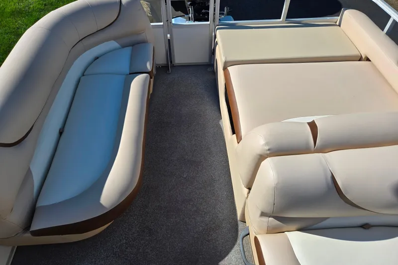 Slide: The Image of 2016 Sun Tracker Party Barge 24 DLX interior with beige seating and spacious layout. - 16