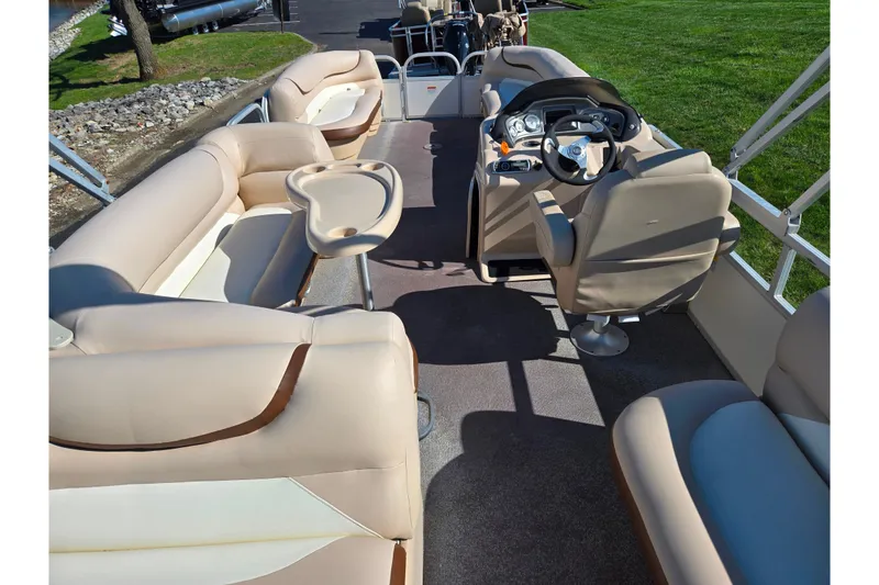 Slide: The Image of 2016 Sun Tracker Party Barge 24 DLX interior with beige seating and steering console. - 19