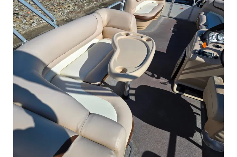 Slide: The Image of 2016 Sun Tracker Party Barge 24 DLX interior with beige seating and table. - 20