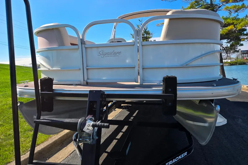 Slide: The Image of 2016 Sun Tracker Party Barge 24 DLX on trailer, parked near a lake. - 6